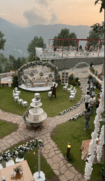 Aerial view of nikah lawn with fountain and mountain backdrop at dusk