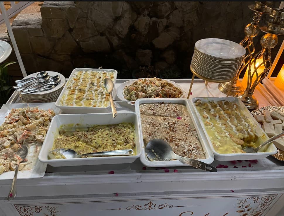 Traditional wedding buffet with desserts and warm evening lighting
