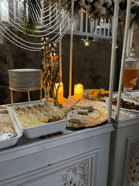 Wedding dessert and catering display with gold platters and candles